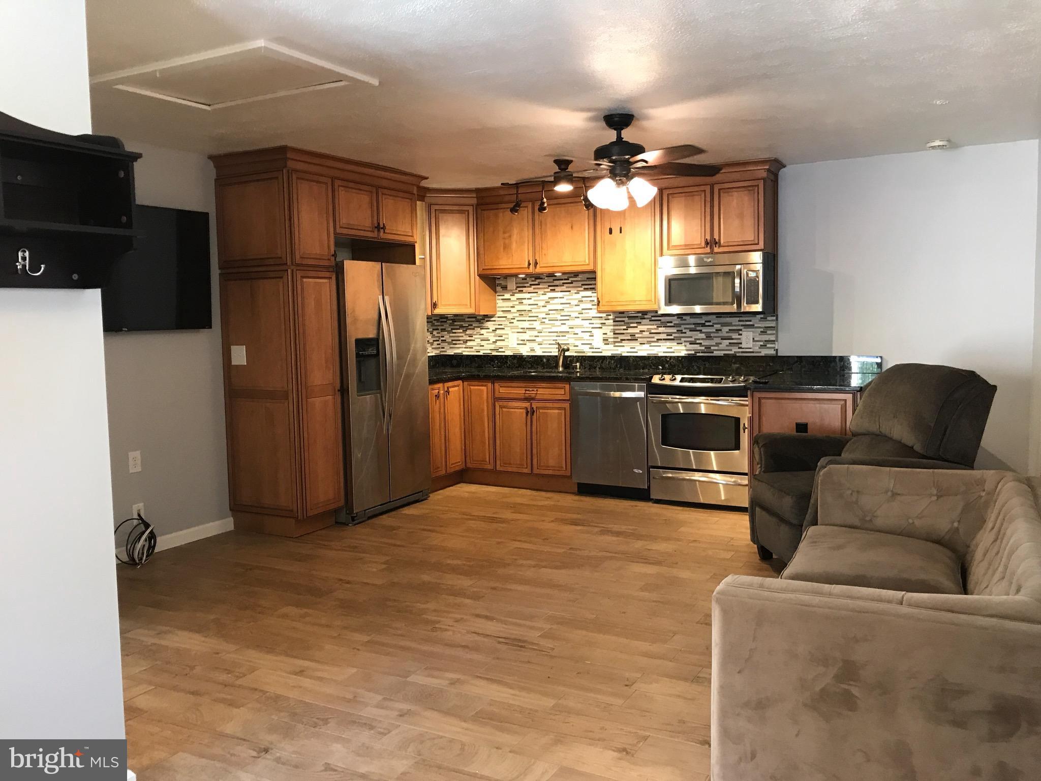 a kitchen with stainless steel appliances granite countertop a refrigerator a stove and a sink