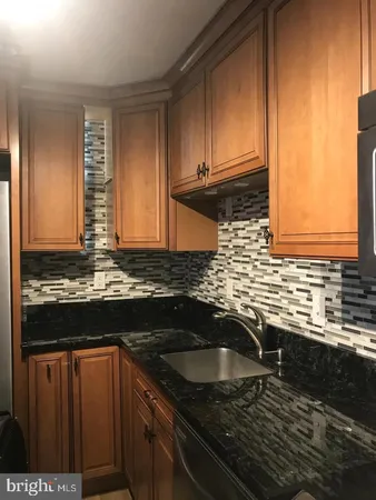 a kitchen with granite countertop a sink and a stove