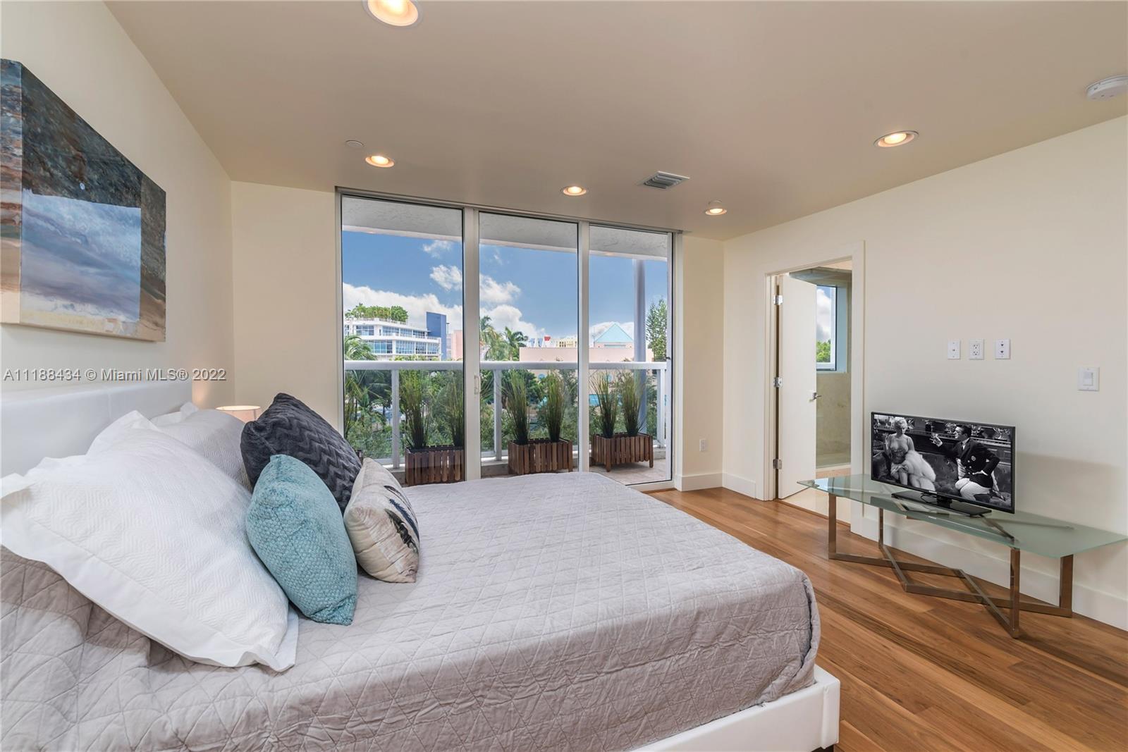 400 Alton Road, Unit TH4A Miami Beach, FL 33139 - Photo 22 of 38 a large bed sitting in a spacious bedroom next to a window