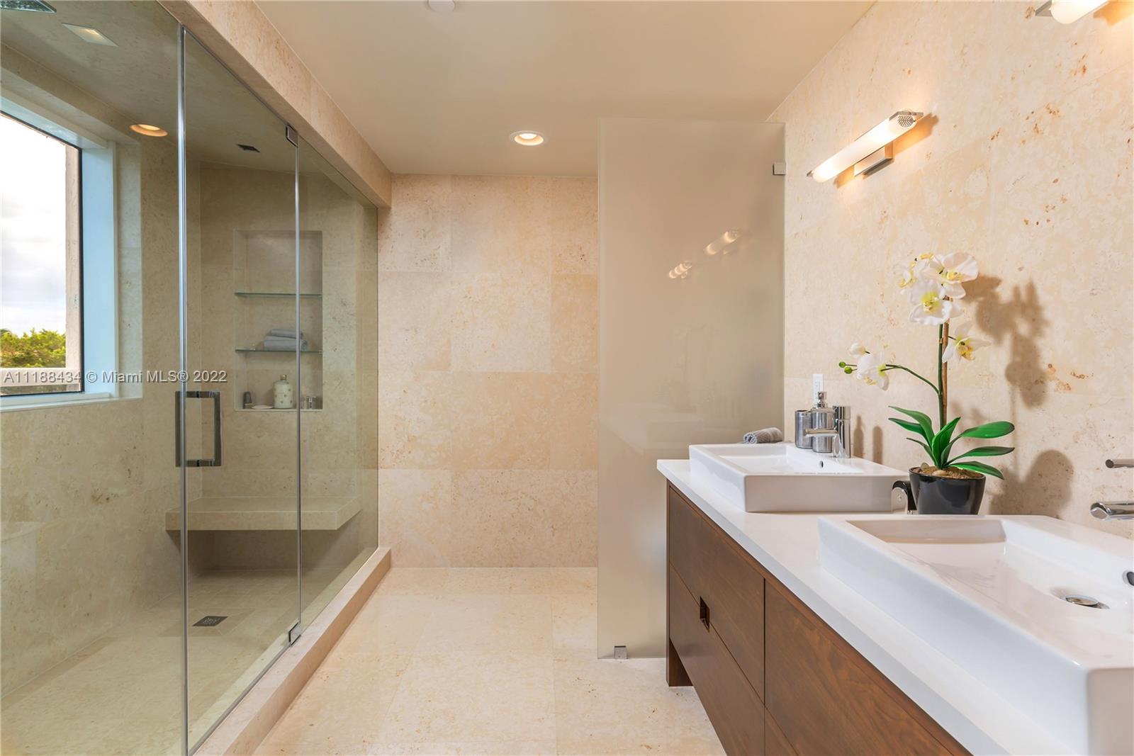 400 Alton Road, Unit TH4A Miami Beach, FL 33139 - Photo 23 of 38 a bathroom with a double vanity sink a mirror and shower