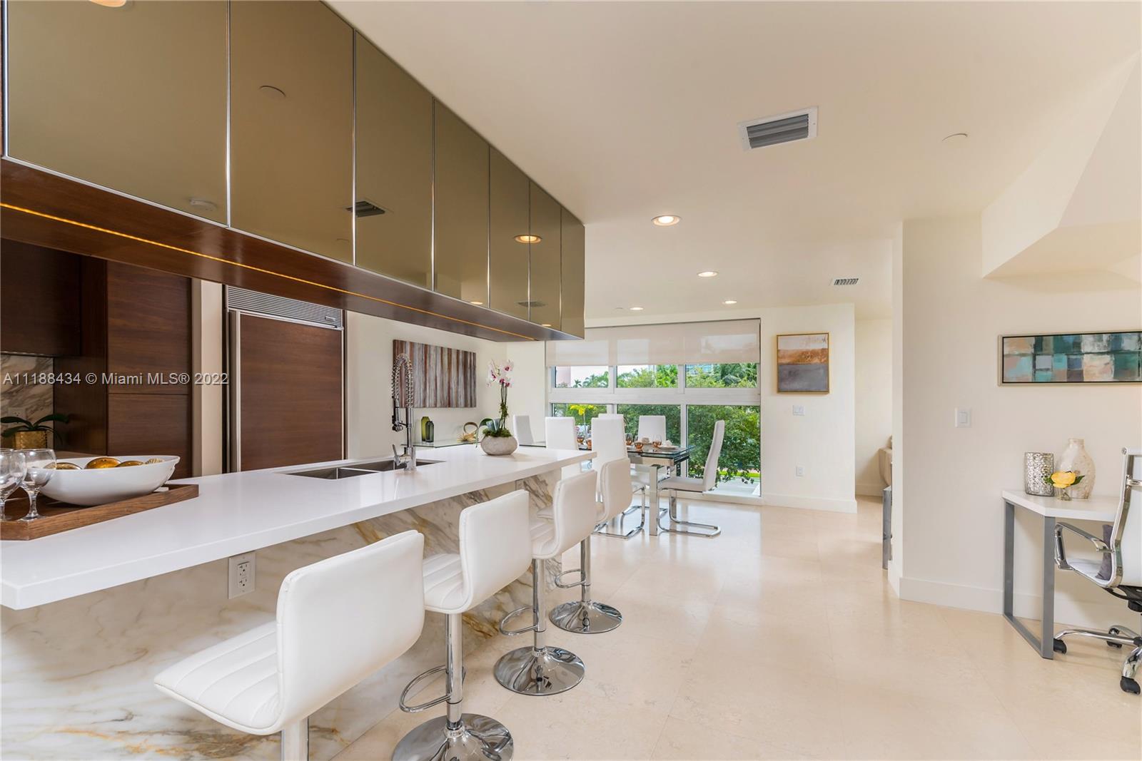 400 Alton Road, Unit TH4A Miami Beach, FL 33139 - Photo 10 of 38 a view of a dining room with furniture one side kitchen view and wooden floor