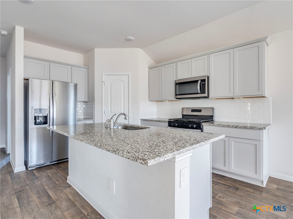 316 Addison Place Lockhart, TX 78644 - Photo 5 of 28 a kitchen with a granite counter tops refrigerator and microwave
