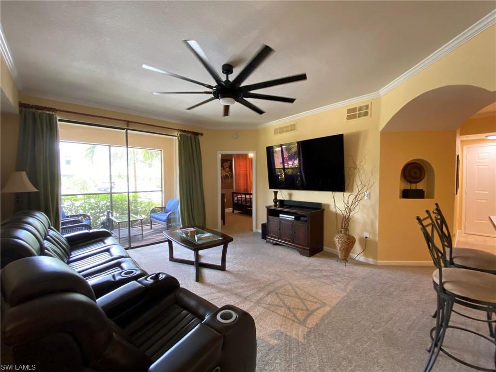 a living room with furniture a ceiling fan and a flat screen tv