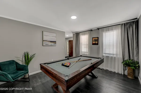 a living room with furniture pool table and a window