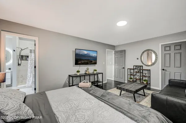 a living room with furniture a flat screen tv and a large window