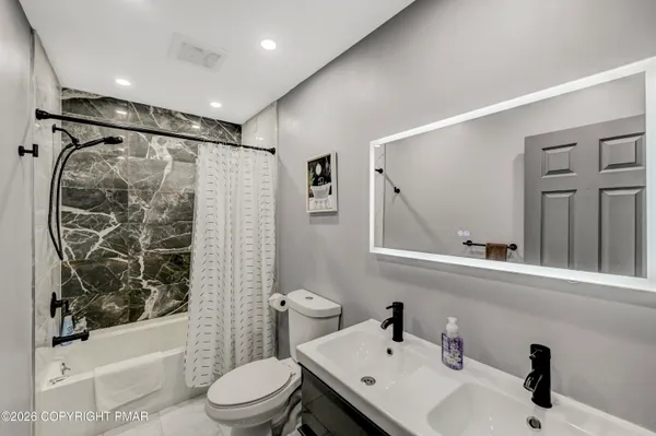 a bathroom with a sink toilet and shower
