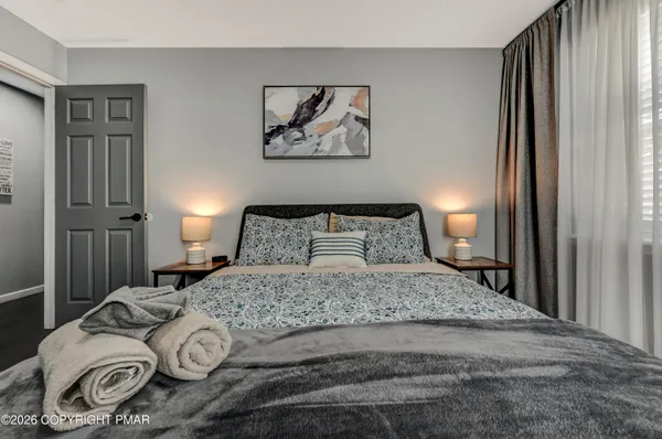 a bedroom with a bed and a painting on the wall