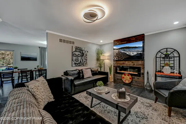 a living room with furniture a rug and a flat screen tv