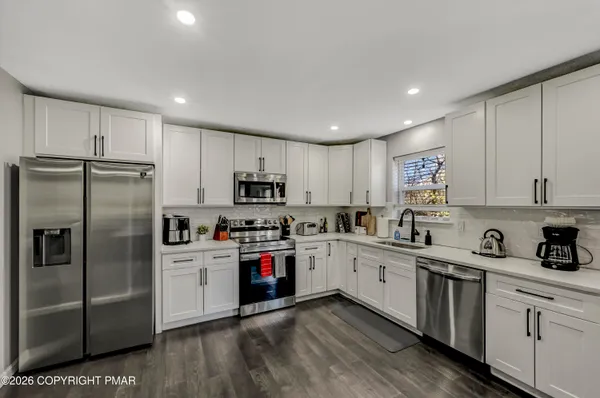 a kitchen with white cabinets stainless steel appliances and sink