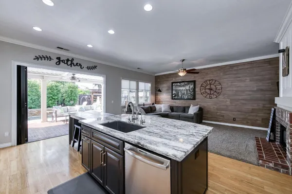 a kitchen with granite countertop sink stove and wooden floor