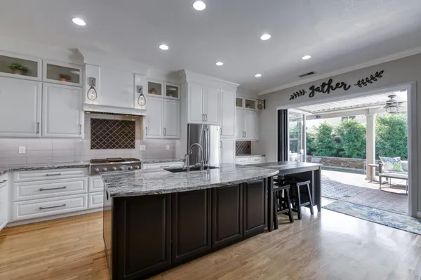a kitchen with stainless steel appliances granite countertop a sink stove and wooden cabinets