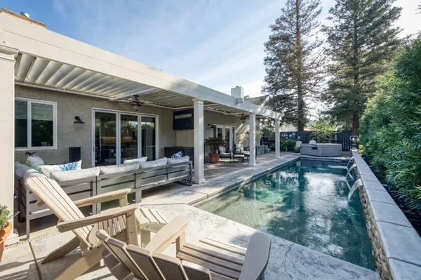 a view of a house with pool lawn chairs and floor to ceiling window