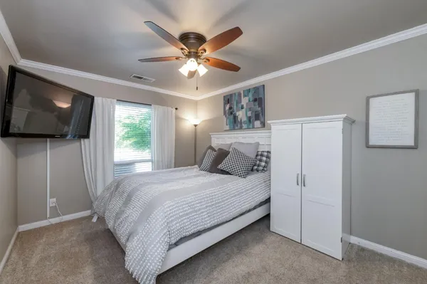 a bedroom with a large bed and a chandelier