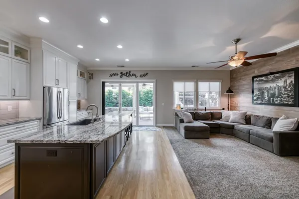 a living room with granite countertop furniture and a wooden floor