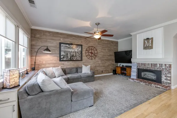a living room with furniture a fireplace and a flat screen tv