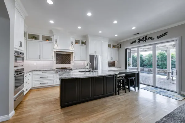 a large kitchen with kitchen island a sink a center island and stainless steel appliances