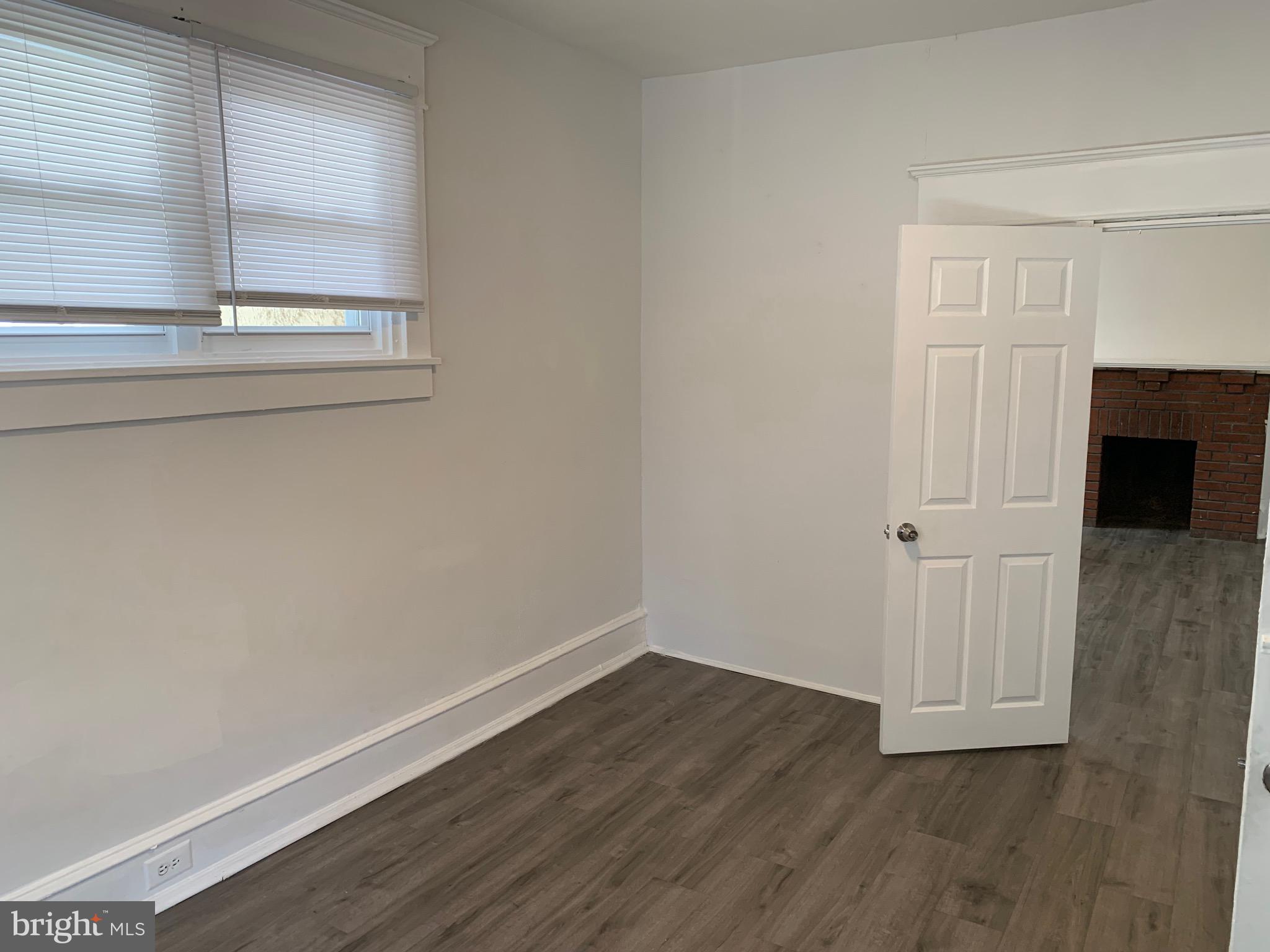 a view of a small space with wooden floor and a window