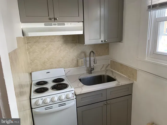 a kitchen with a sink a stove and cabinets