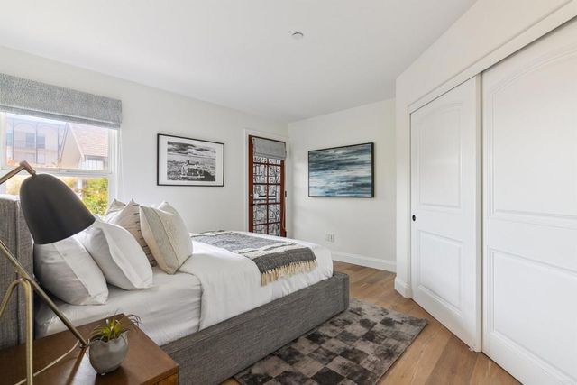 a bedroom with a bed and wooden floor