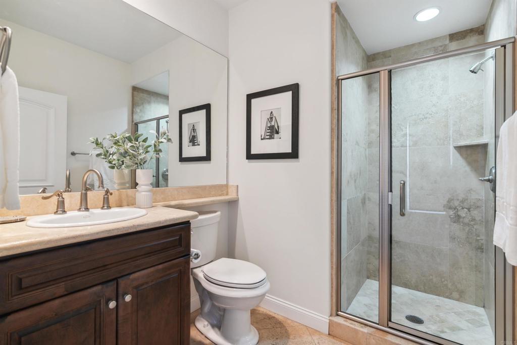848 Prospect Street, Unit E La Jolla, CA 92037 - Photo 12 of 16 a bathroom with a toilet a sink and glass door