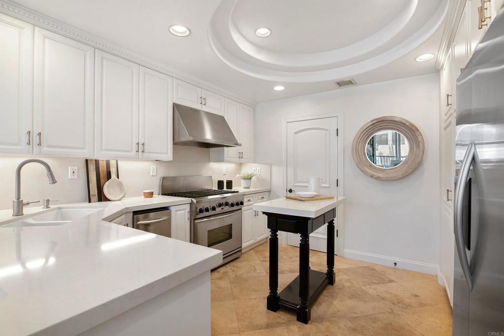 848 Prospect Street, Unit E La Jolla, CA 92037 - Photo 3 of 16 a kitchen with stainless steel appliances granite countertop a sink a stove and a refrigerator