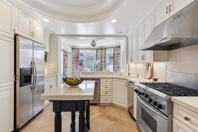 a kitchen with stainless steel appliances a table chairs stove and refrigerator