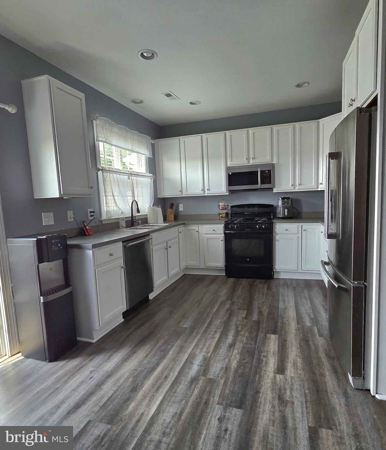 34 Springfield Circle Middletown, DE 19709 - Photo 10 of 34 a kitchen with wooden floors and white cabinets