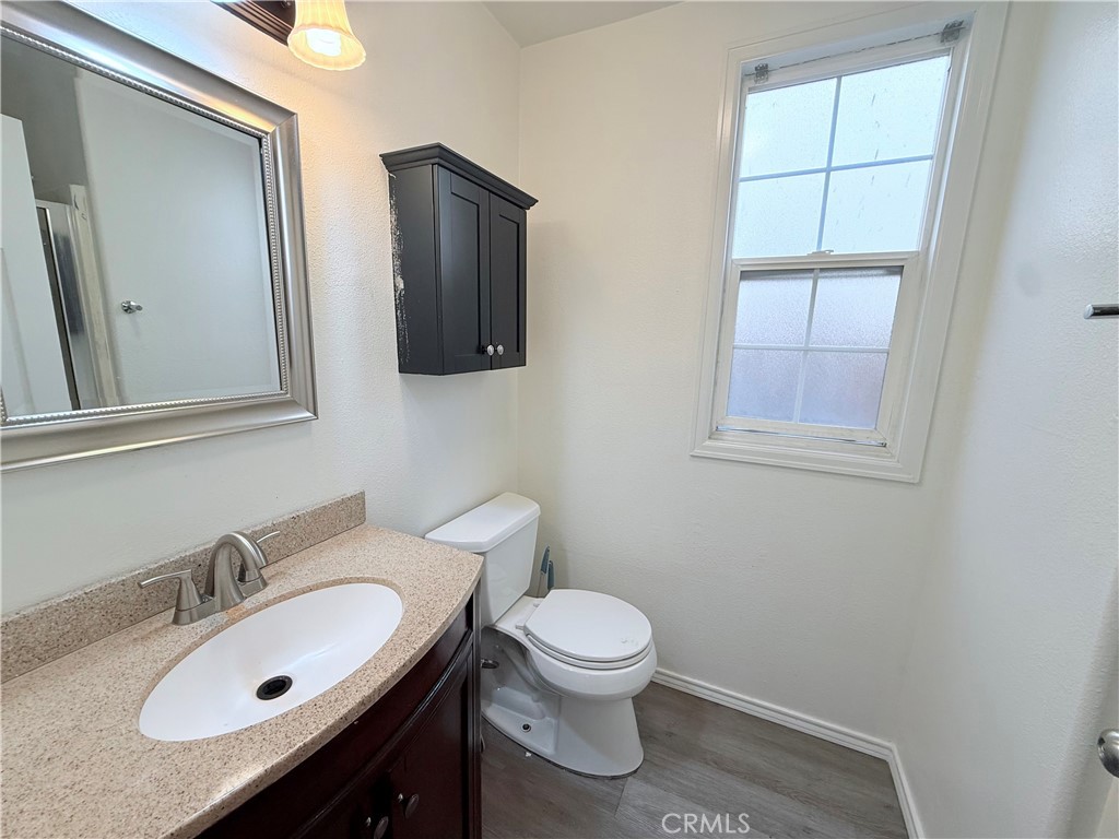 9287 Sierra Vista Circle Pico Rivera, CA 90660 - Photo 8 of 16 a bathroom with a granite countertop toilet sink and mirror