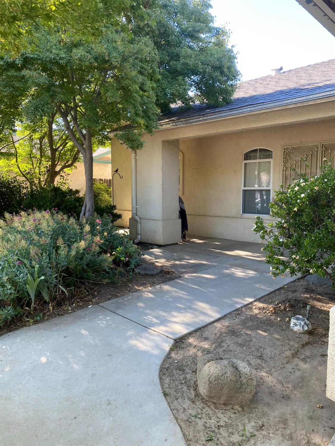 609 Merlot Avenue Madera, CA 93637 - Photo 4 of 45 a view of a house with a small yard and a large tree