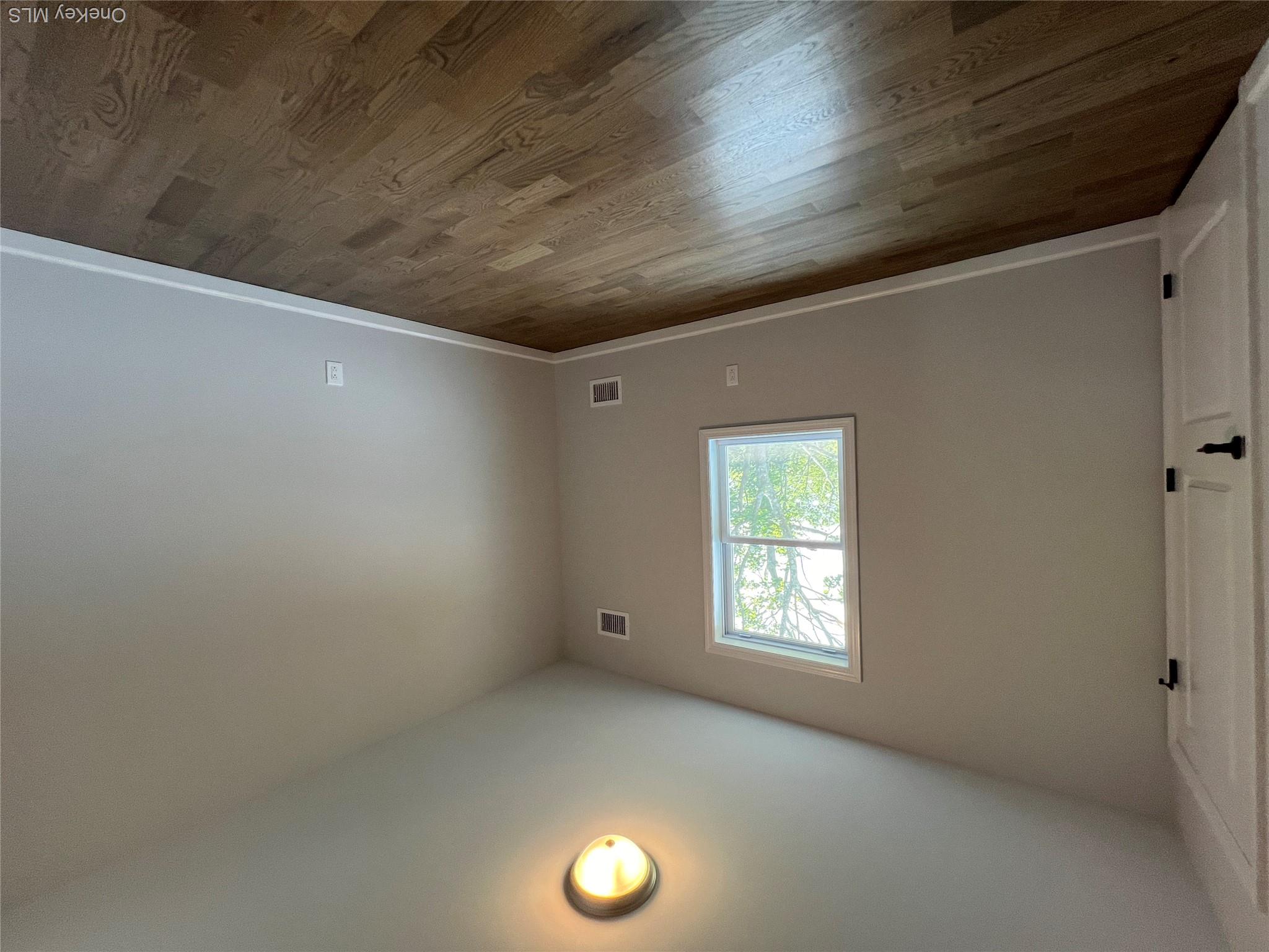 35 Babylon Road Mastic Beach, NY 11951 - Photo 13 of 19 an empty room with wooden floor and windows