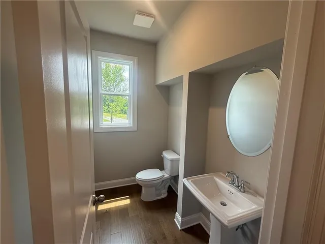 a bathroom with a toilet sink and mirror