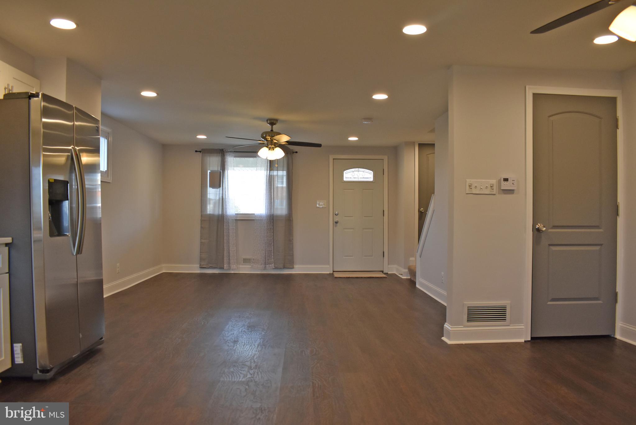 7809 Harold Road Baltimore, MD 21222 - Photo 11 of 36 a view of an empty room with wooden floor and a kitchen