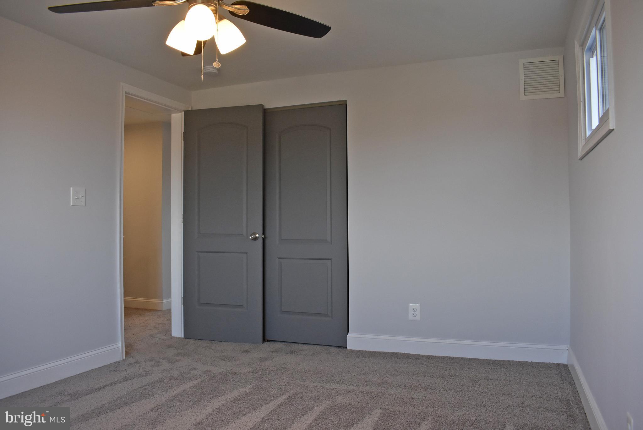7809 Harold Road Baltimore, MD 21222 - Photo 23 of 36 an empty room with a chandelier fan