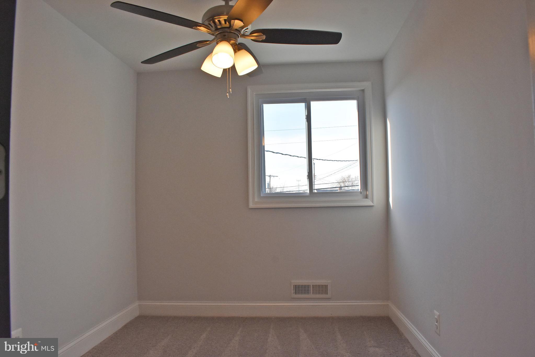 7809 Harold Road Baltimore, MD 21222 - Photo 26 of 36 an empty room with a window and a fan
