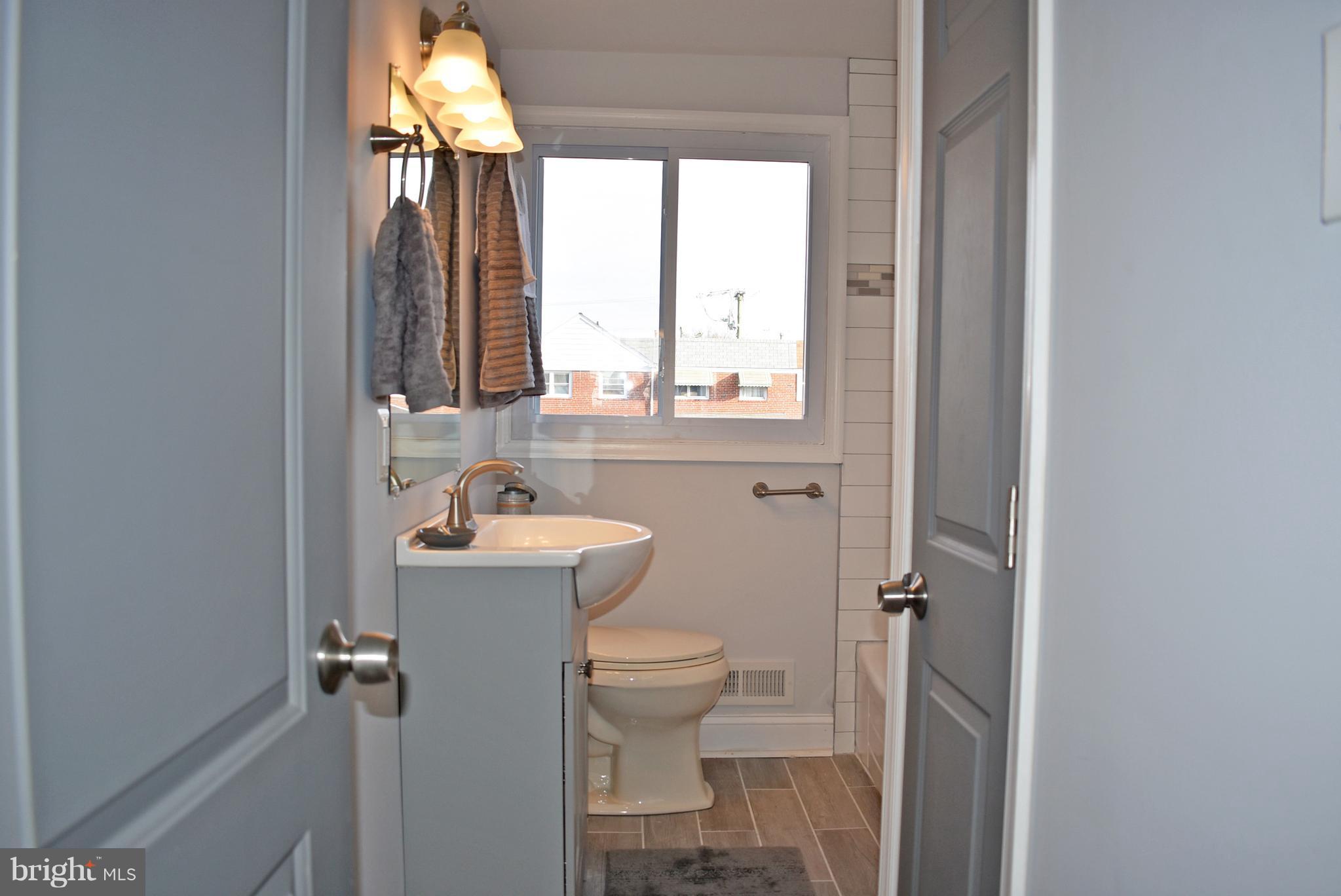 7809 Harold Road Baltimore, MD 21222 - Photo 28 of 36 a bathroom with a sink a toilet and a window