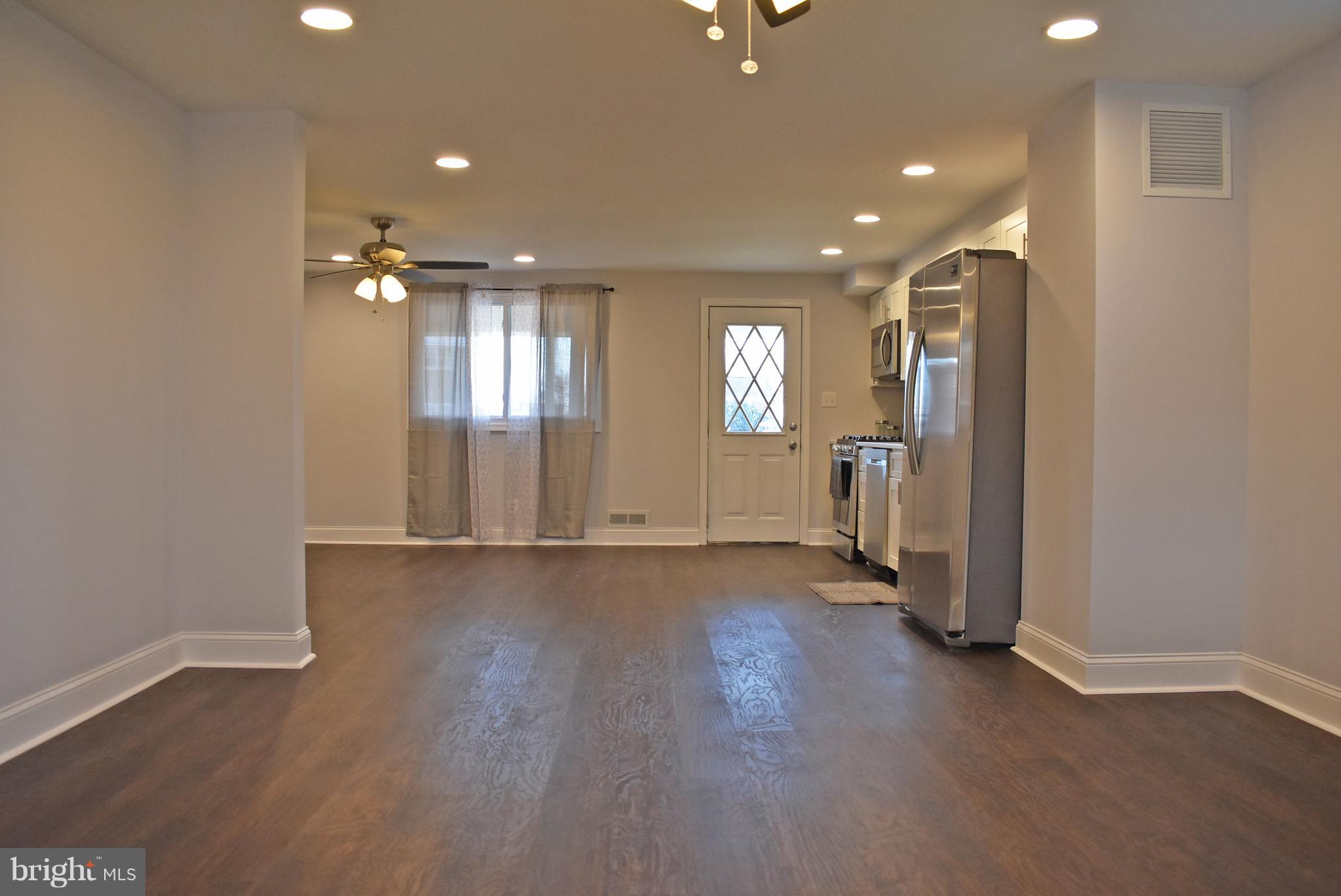 7809 Harold Road Baltimore, MD 21222 - Photo 6 of 36 an empty room with wooden floor and windows