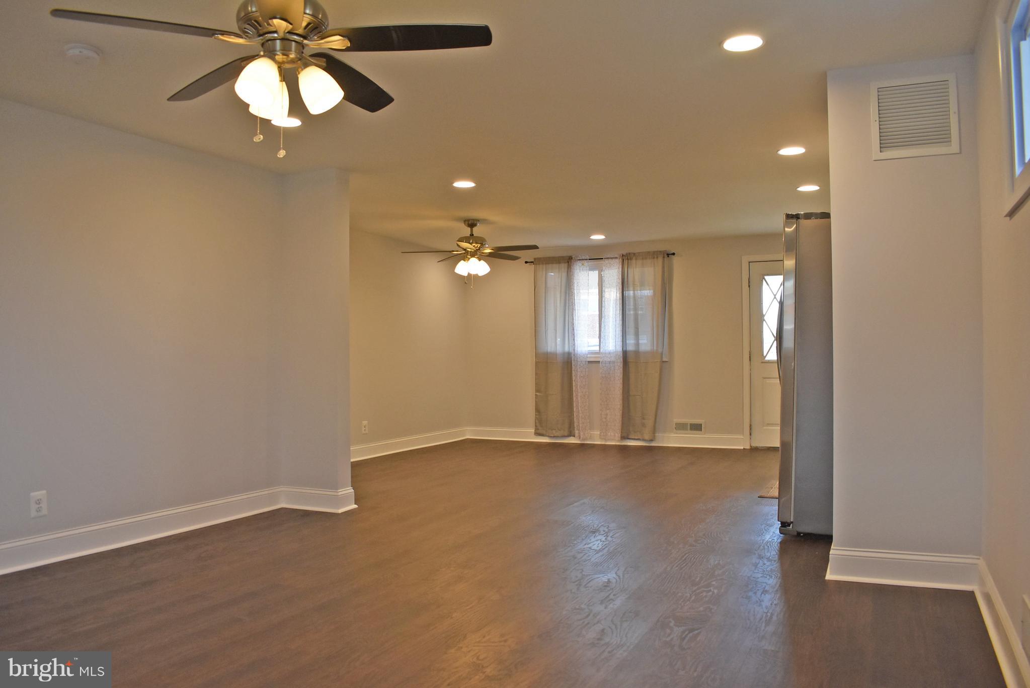7809 Harold Road Baltimore, MD 21222 - Photo 7 of 36 an empty room with wooden floor and windows