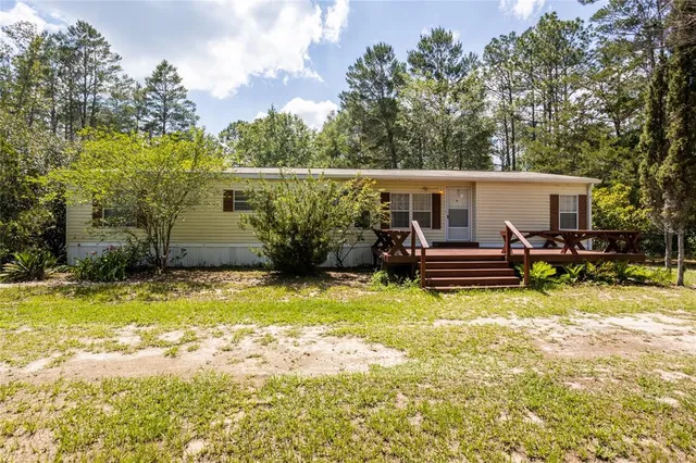 a view of swimming pool with lawn chairs and plants