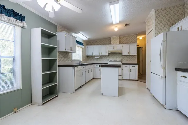 a kitchen with white cabinets and white appliances