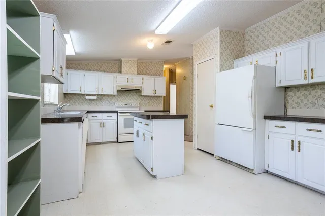 a kitchen with white cabinets and white appliances