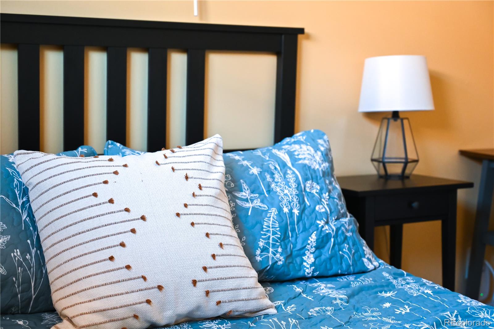 7051 Ruth Way Denver, CO 80221 - Photo 18 of 36 a bed sitting in a bedroom next to a window