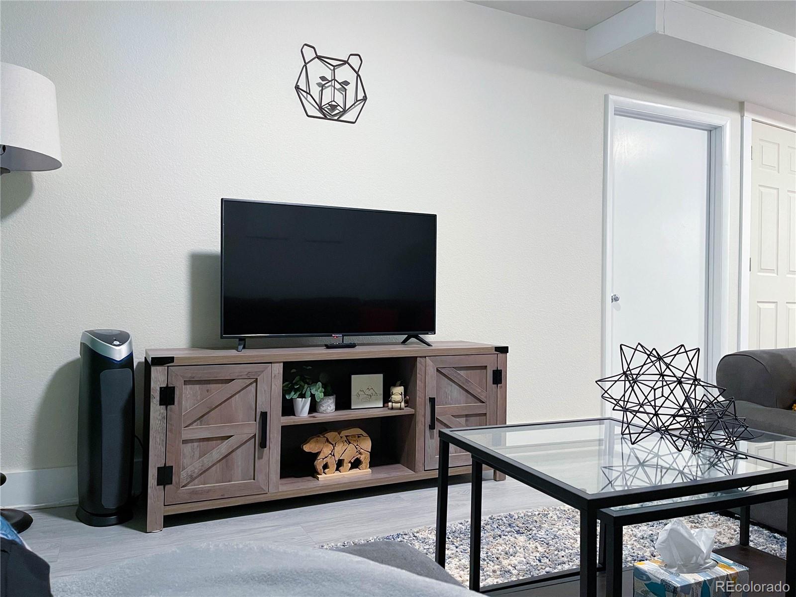 7051 Ruth Way Denver, CO 80221 - Photo 25 of 36 a living room with furniture and a flat screen tv