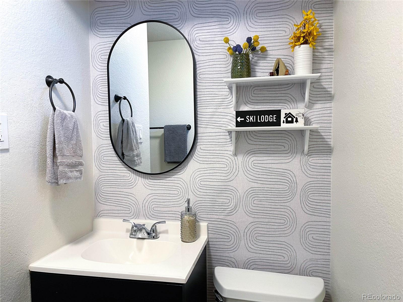 7051 Ruth Way Denver, CO 80221 - Photo 30 of 36 a bathroom with a toilet sink and mirror