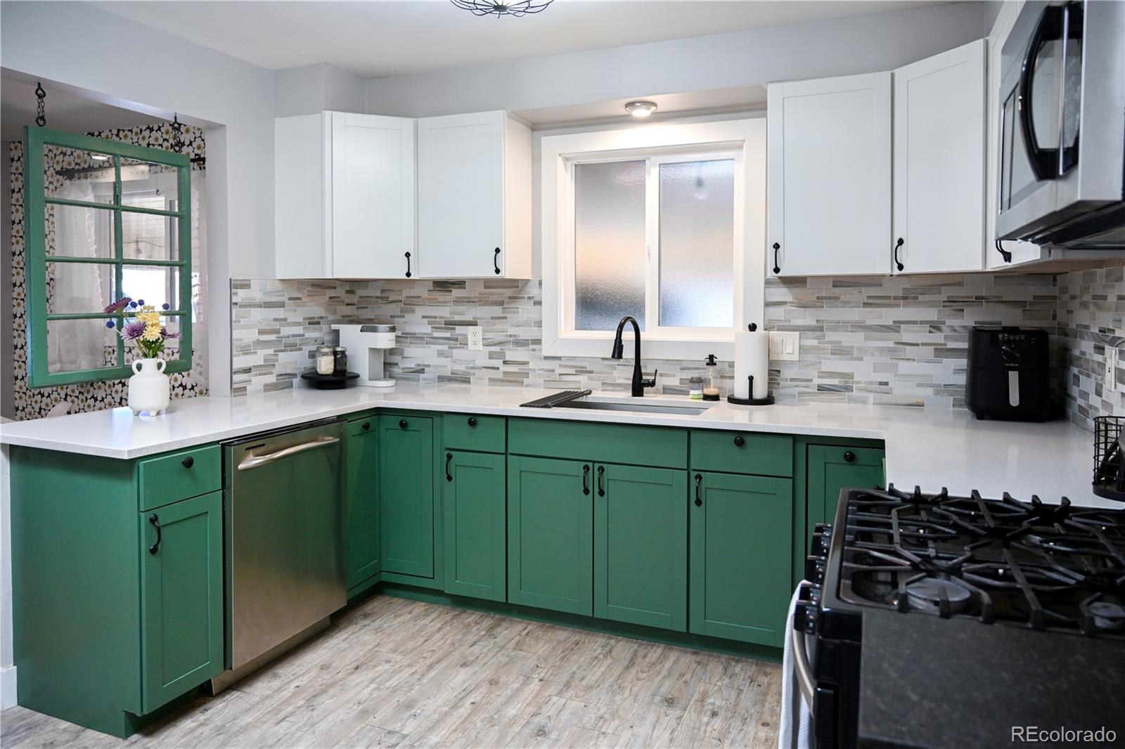 7051 Ruth Way Denver, CO 80221 - Photo 6 of 36 a kitchen with sink a microwave and cabinets