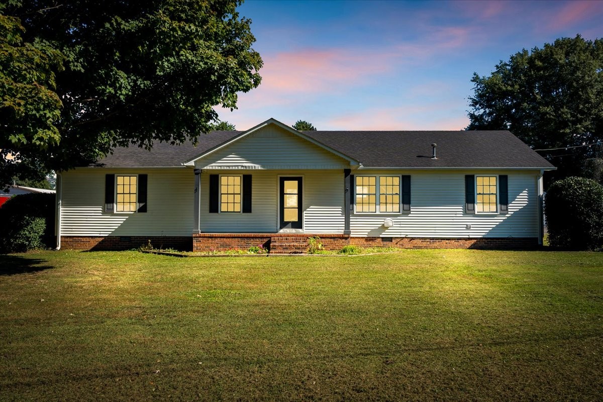 a view of a house with swimming pool next to a yard