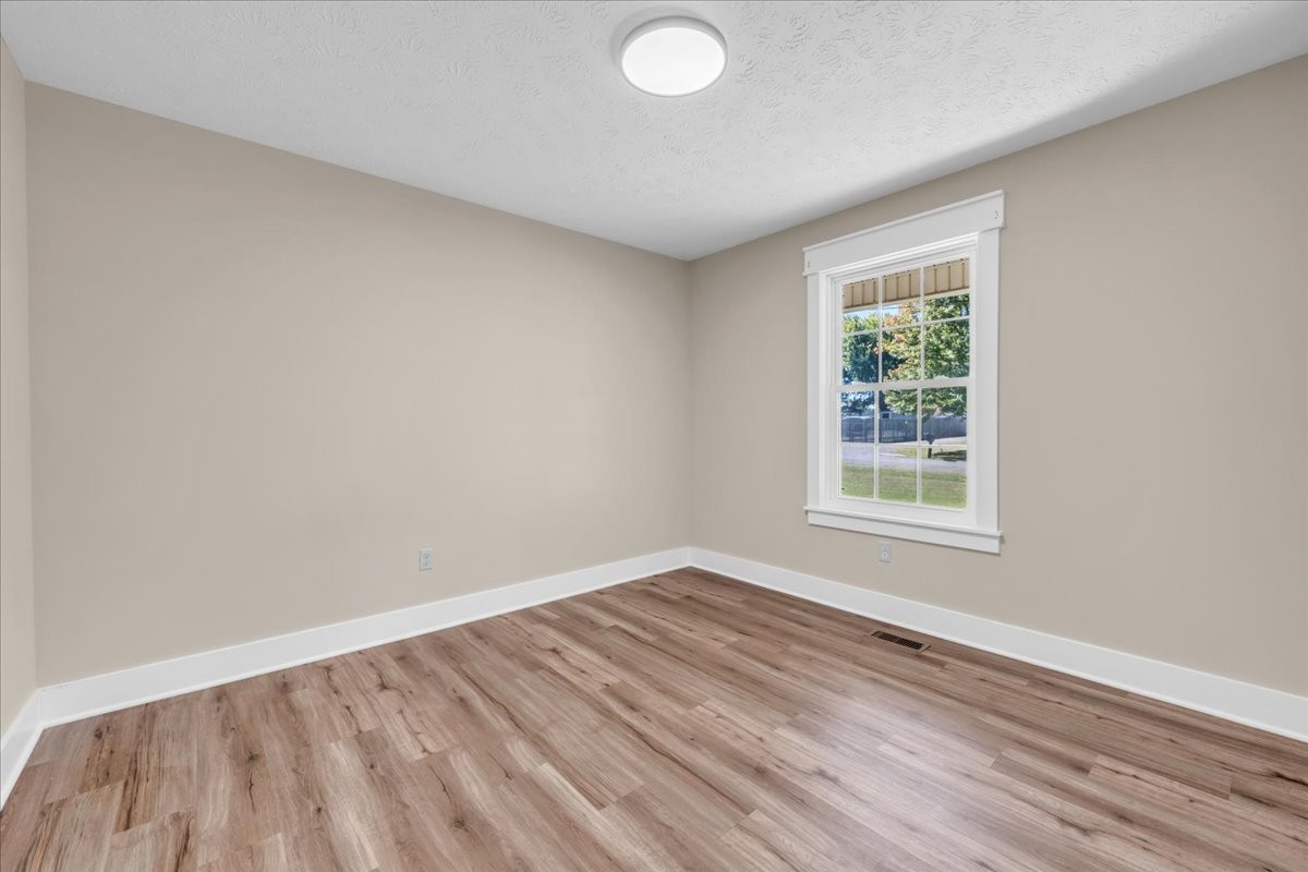 145 Hawkins Road Smithville, TN 37166 - Photo 22 of 45 an empty room with wooden floor and windows