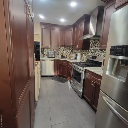 a kitchen with stainless steel appliances granite countertop a refrigerator and a stove