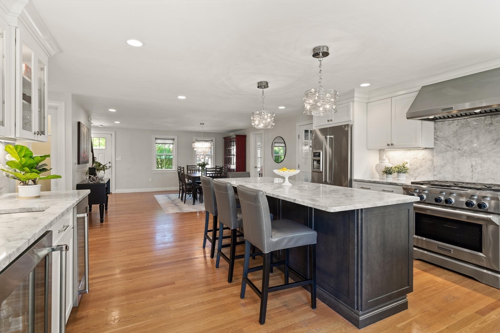 26 Stowell Road Winchester, MA 01890 - Photo 14 of 42 a kitchen with stainless steel appliances a dining table chairs stove and white cabinets