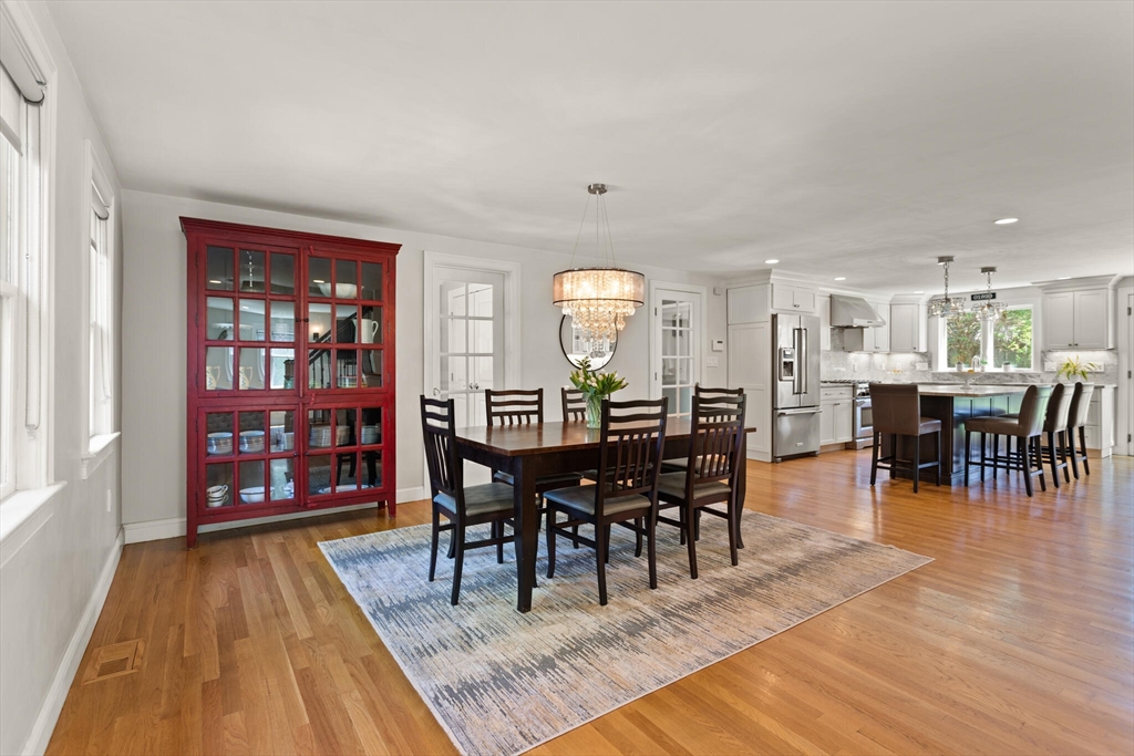 26 Stowell Road Winchester, MA 01890 - Photo 10 of 42 a view of a dining room and livingroom with furniture wooden floor a rug and a painting
