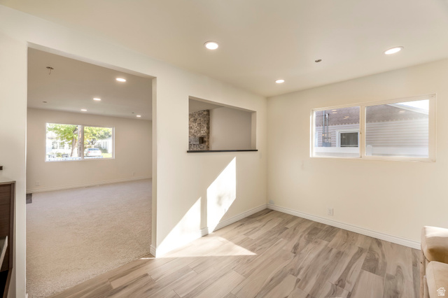 4658 Box Elder Street Salt Lake City, UT 84107 - Photo 7 of 17 Spacious room featuring wood-finish flooring, recessed lighting, and a pass-through window with a stone accent wall